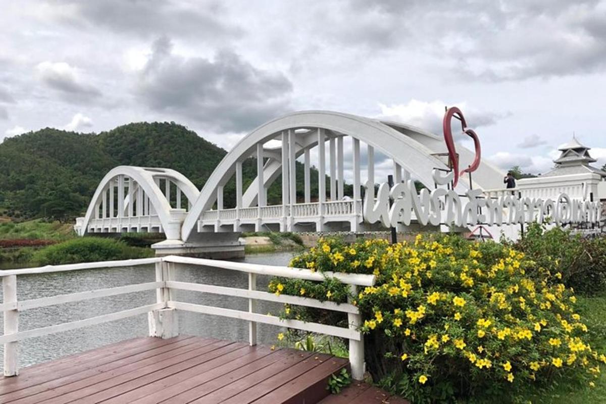 jambatan putih di atas sungai dengan bunga