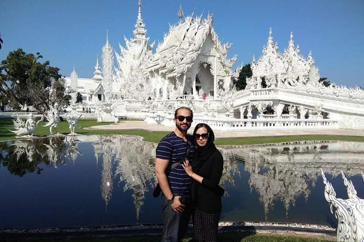 ein Mann und eine Frau posieren vor einem weißen Tempel