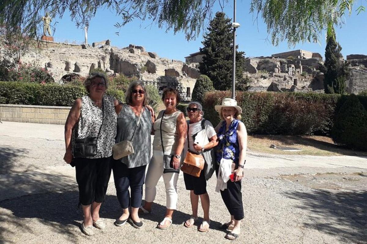 Un grupo de mujeres posando para una foto frente a la acrópolis.