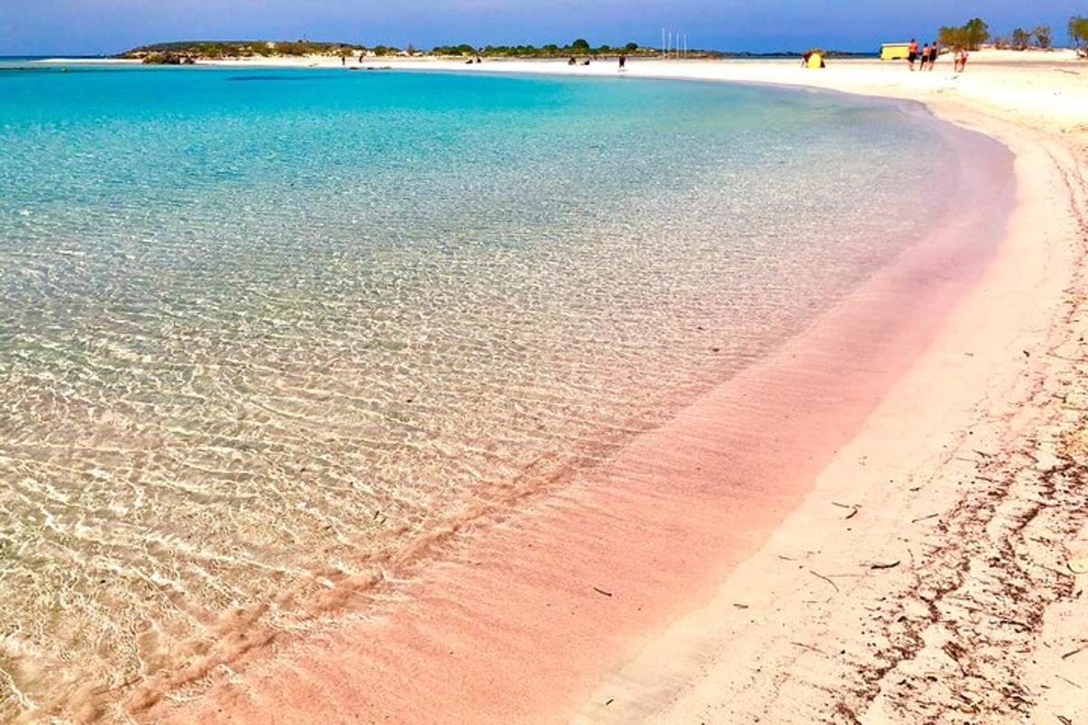 pantai dengan air biru dan orang berjalan di atasnya