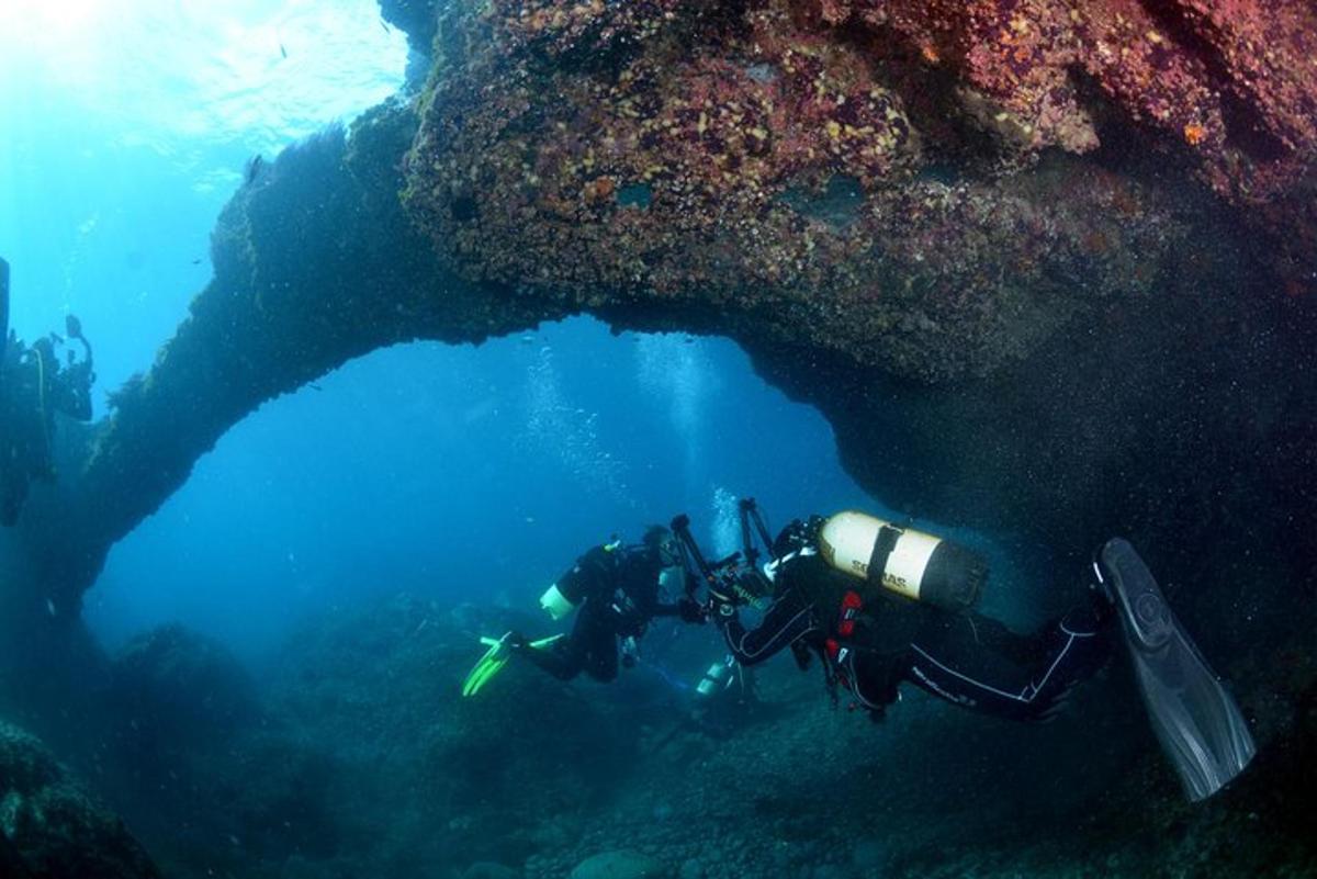 člověk plave ve vodě poblíž skalního útvaru