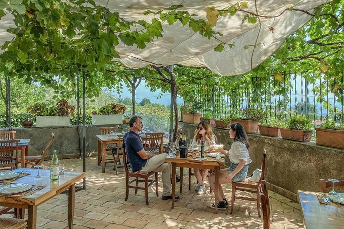 a group of people sitting at a table under an umbrella