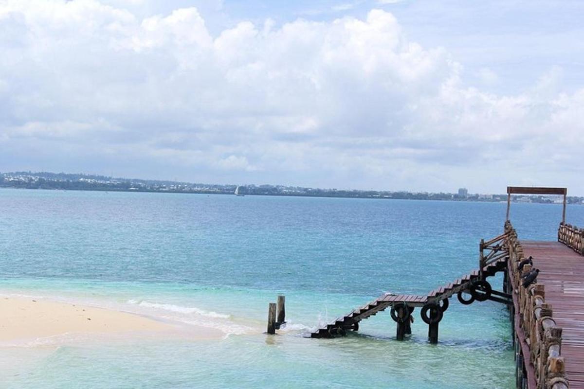un molo di legno nell'acqua vicino a una spiaggia