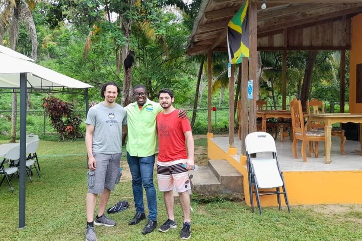 Tres hombres posando para una foto frente a una casa