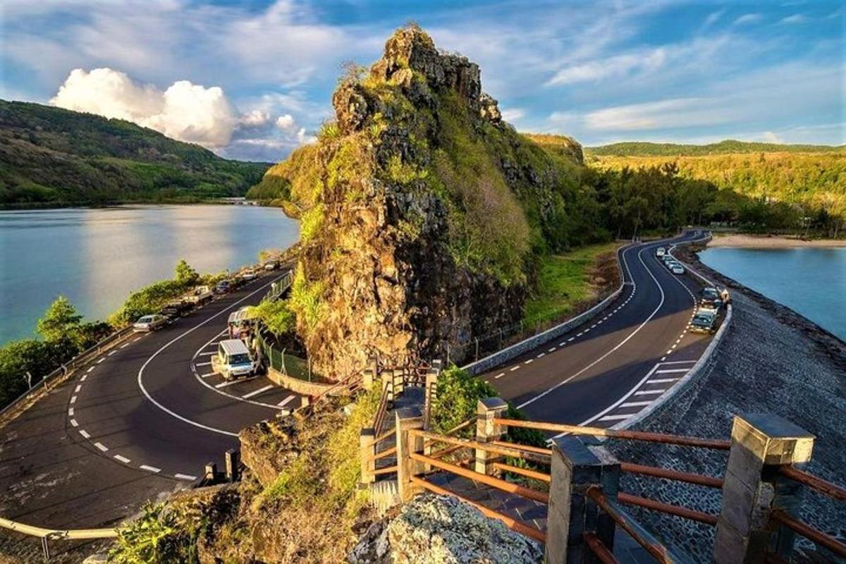 uma montanha com uma estrada próxima a um corpo d'água