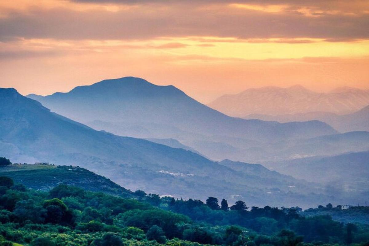 una vista di una catena montuosa al tramonto