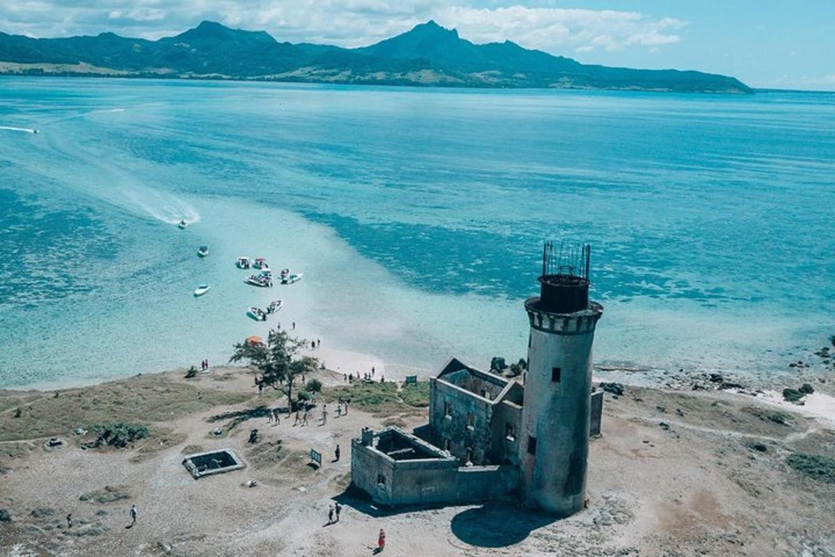 sebuah rumah api di pantai dengan orang di dalam air