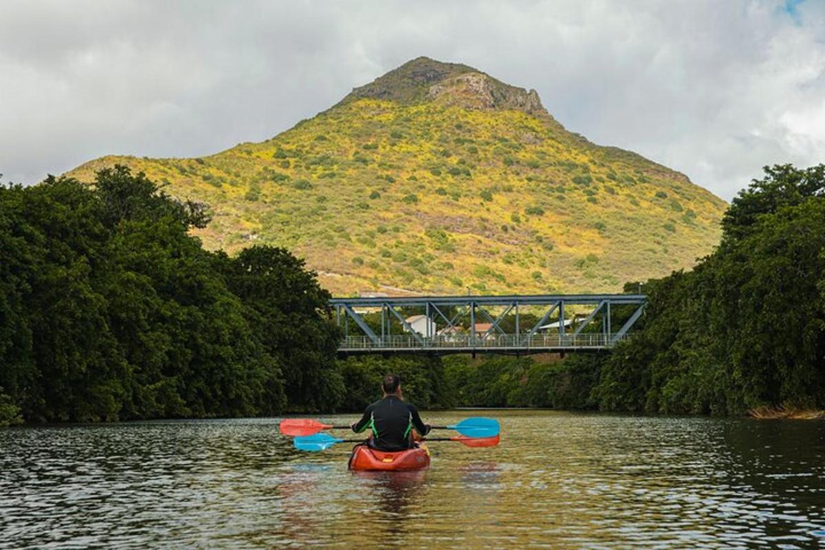 un uomo in kayak su un fiume con una montagna