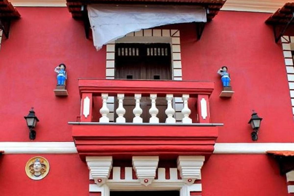 un edificio rosso con un balcone rosso e bianco