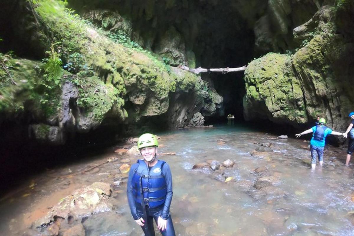 a group of people standing in the water in a cave