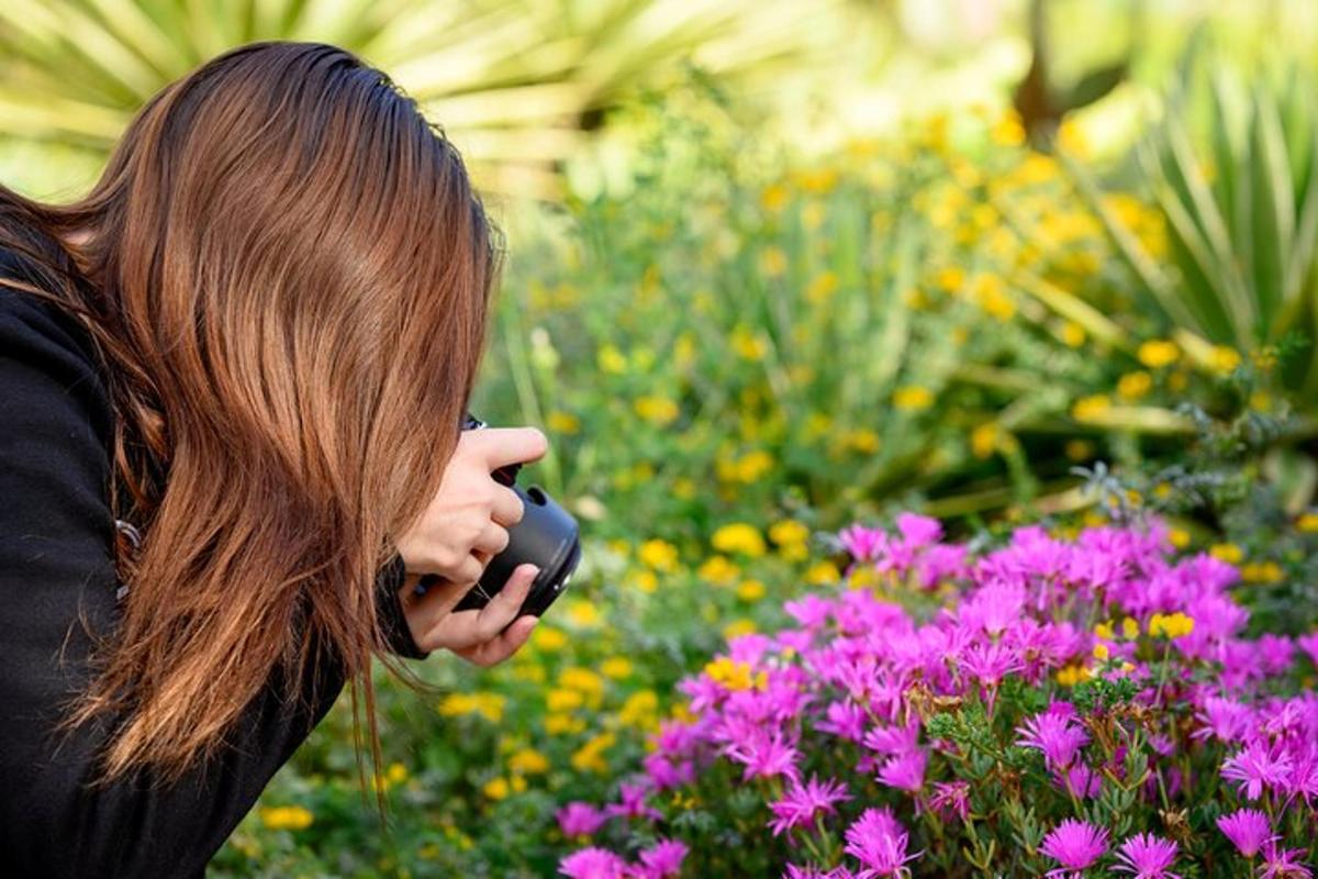 a woman talking on a cell phone in front of flowers