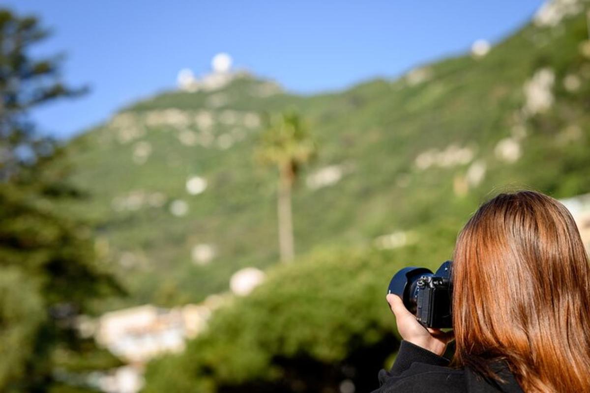 a woman taking a picture of a mountain with a camera
