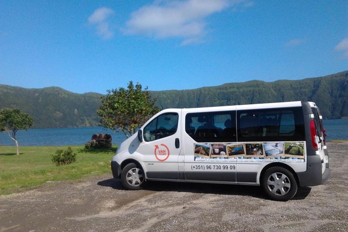 una furgoneta blanca aparcada al costat d'una massa d'aigua