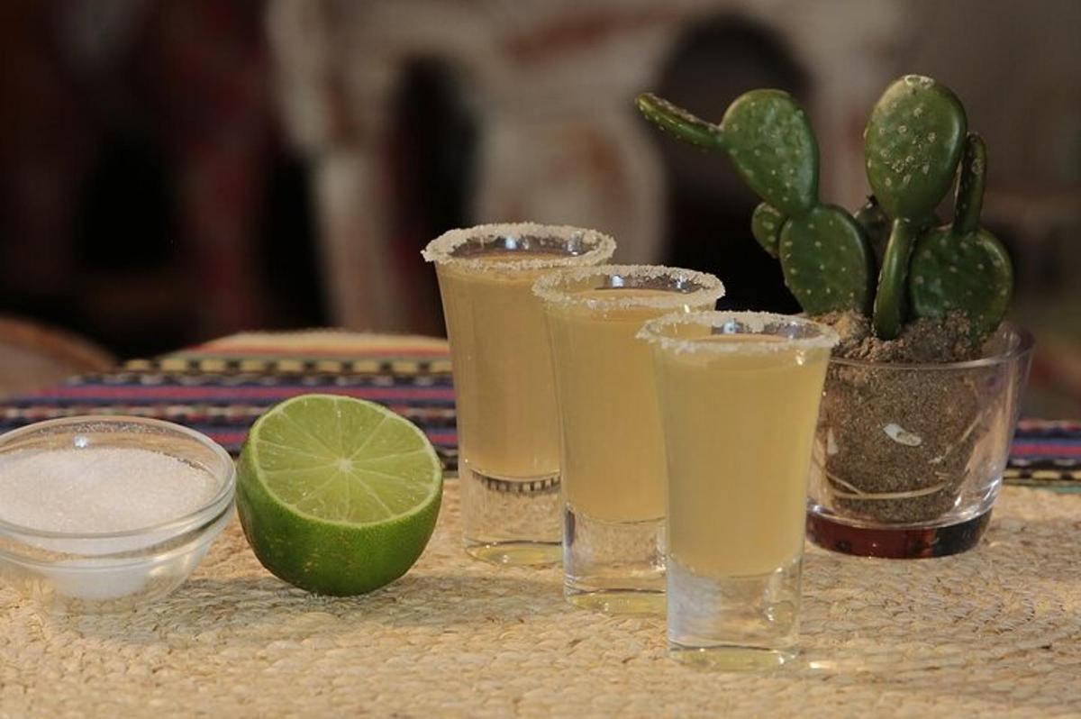 a table with four glasses of juice and a lime