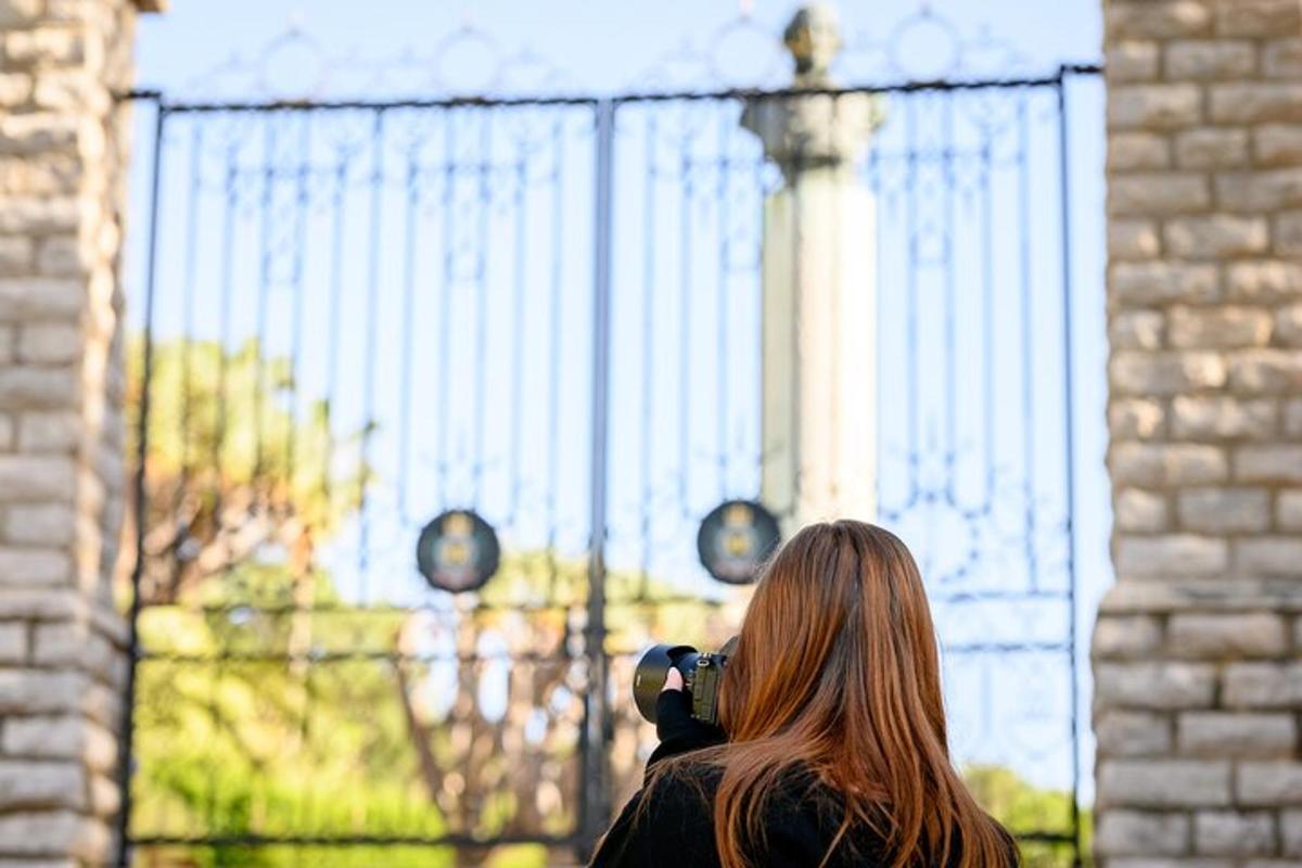 a woman taking a picture of a monument with a camera
