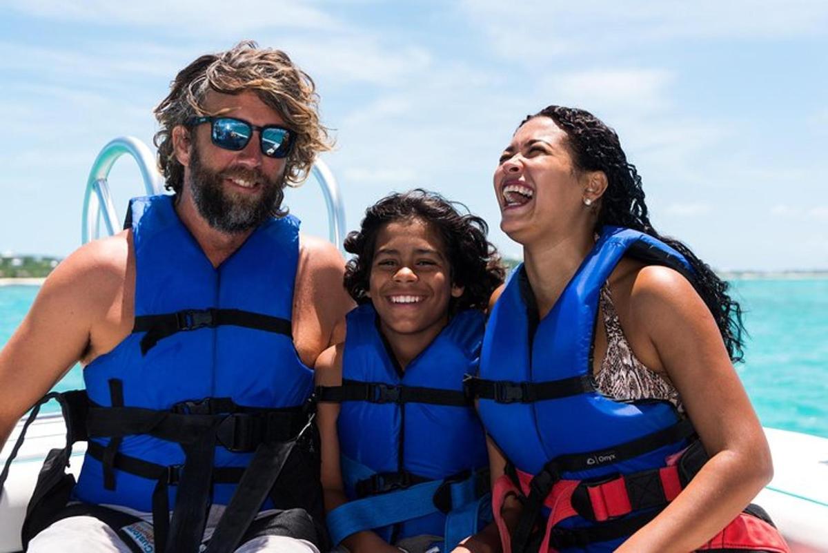 a man and two women in life jackets on a boat