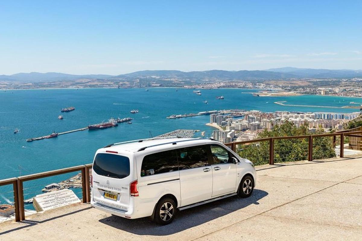a white van parked on a ledge near the water