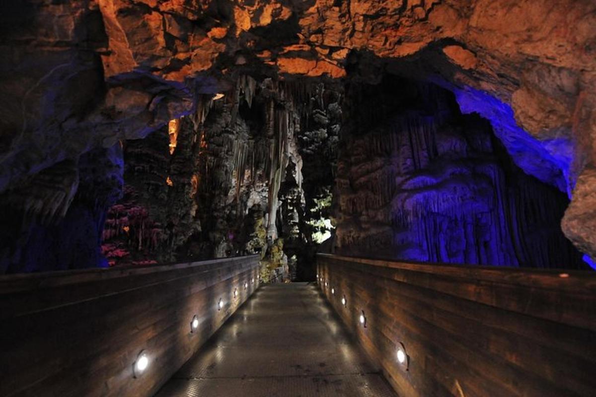 a tunnel in a cave with a large painting on the wall