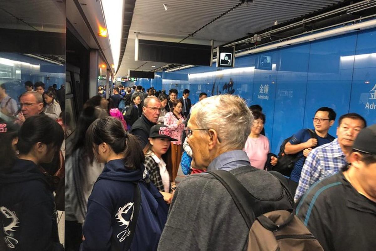 uma multidão de pessoas em pé em uma estação de trem