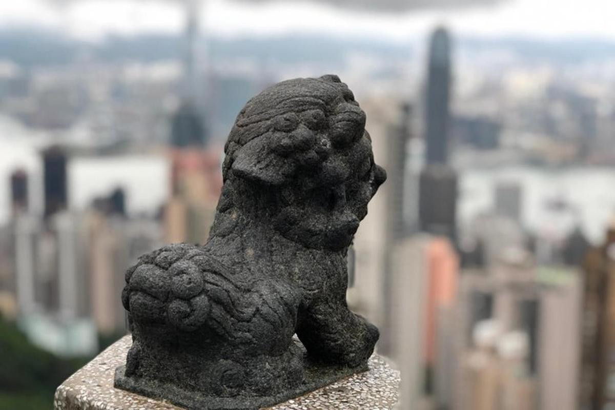 uma estátua de um cachorro sentado no topo de um prédio