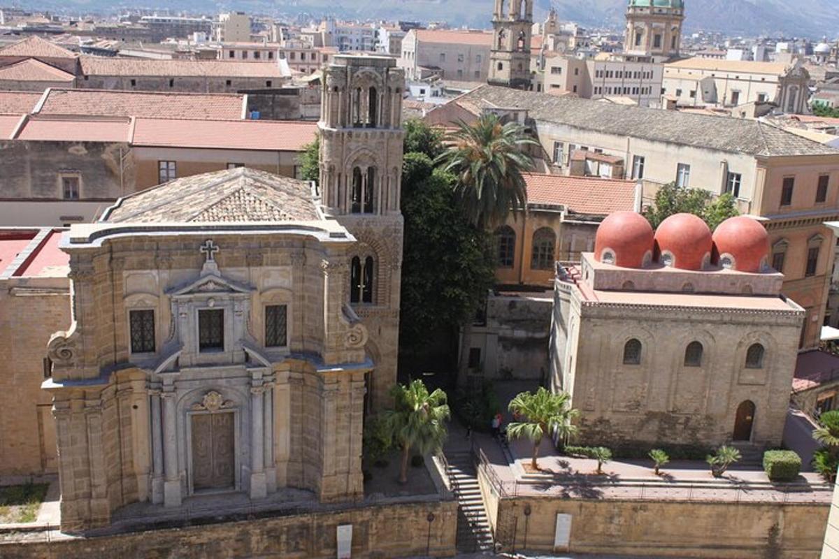 un vecchio edificio con cupole rosse in cima a una città