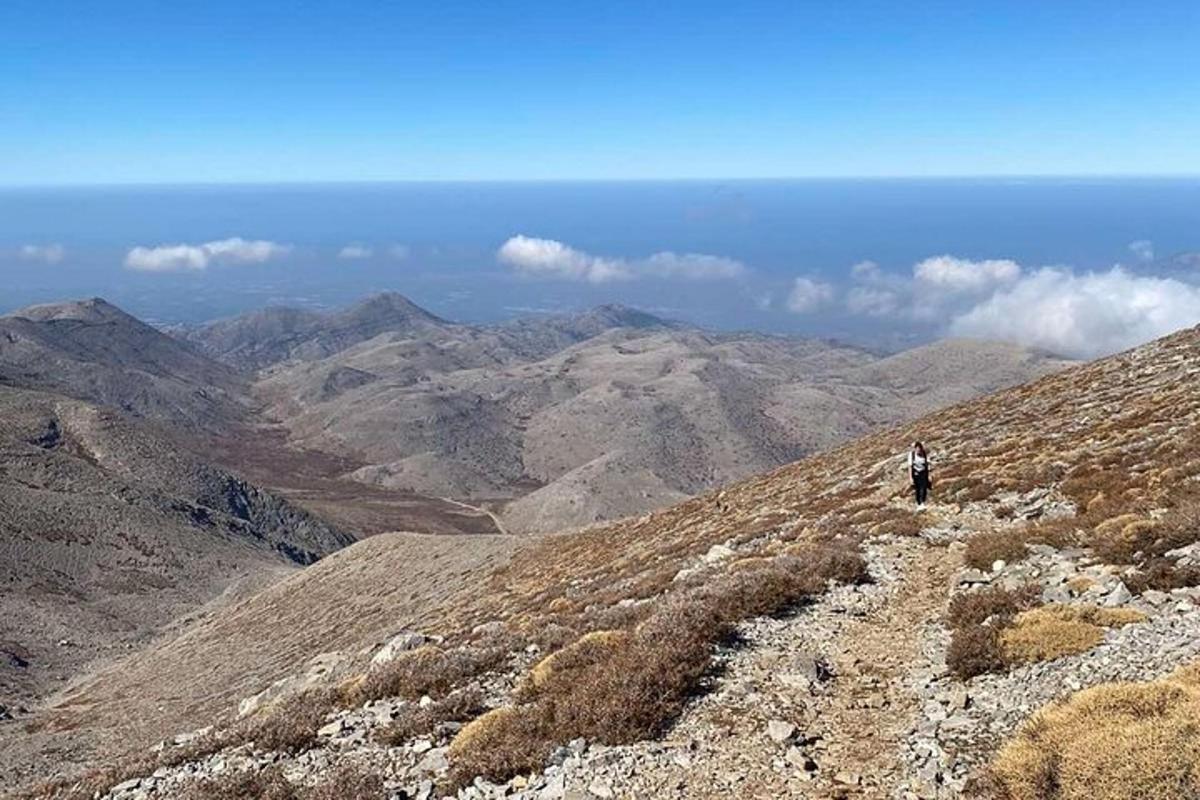 maður stendur á fjalli og horfir á útsýnið