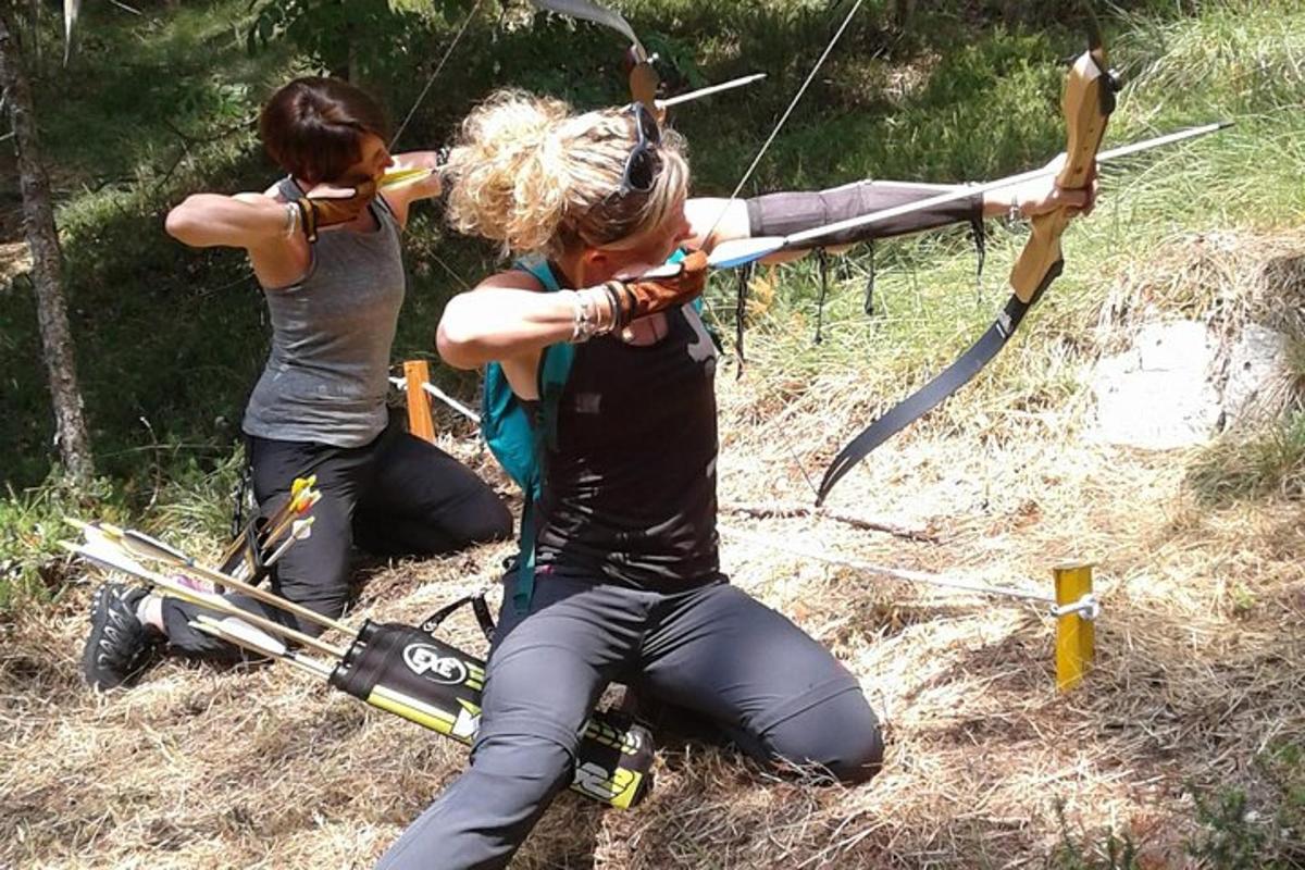 dvě ženy klečí se šípy