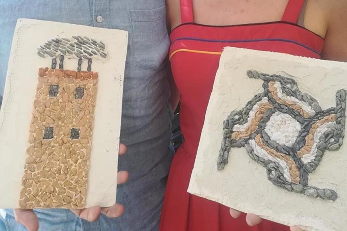 two people holding up paintings of a house