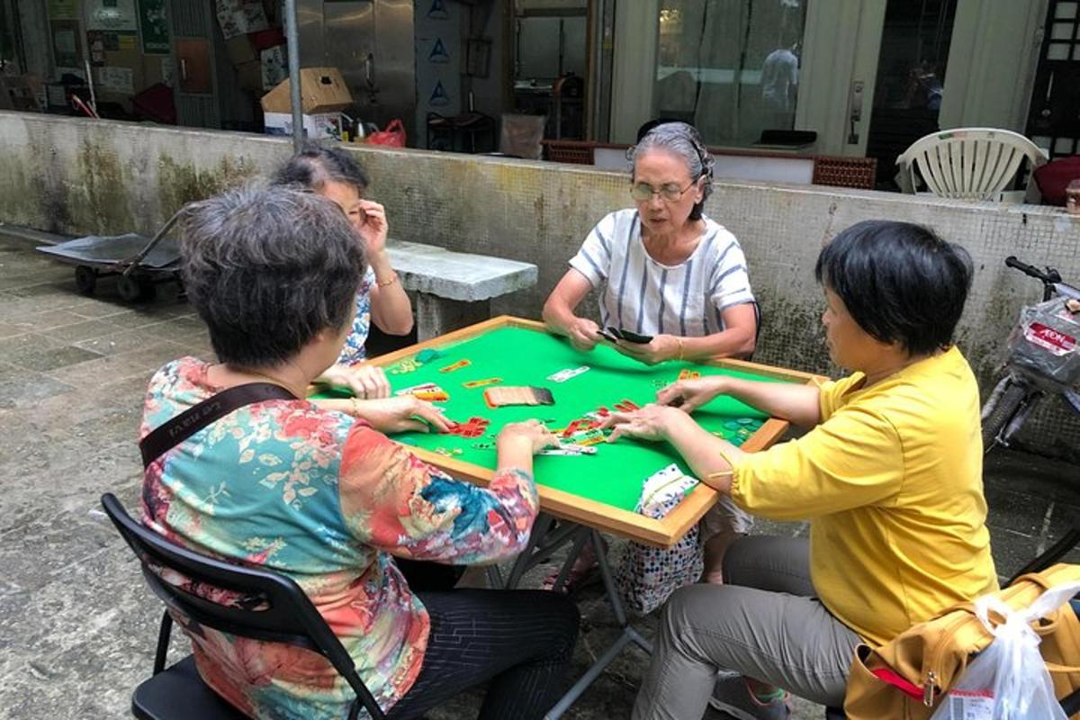 skupina lidí sedících kolem stolu a hrajících poker