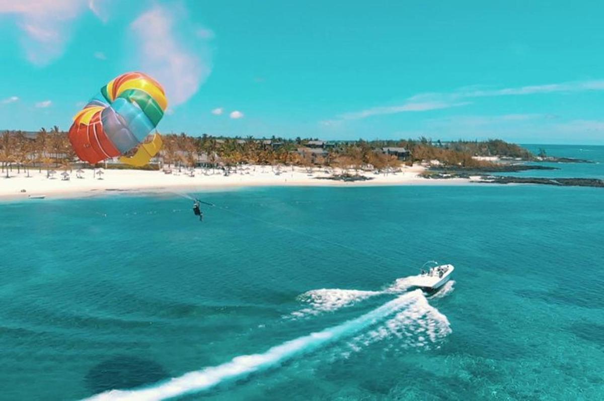 seseorang berselancar layang di laut dengan pantai