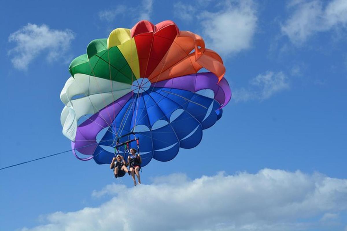 una persona che cavalca un paracadute colorato nel cielo