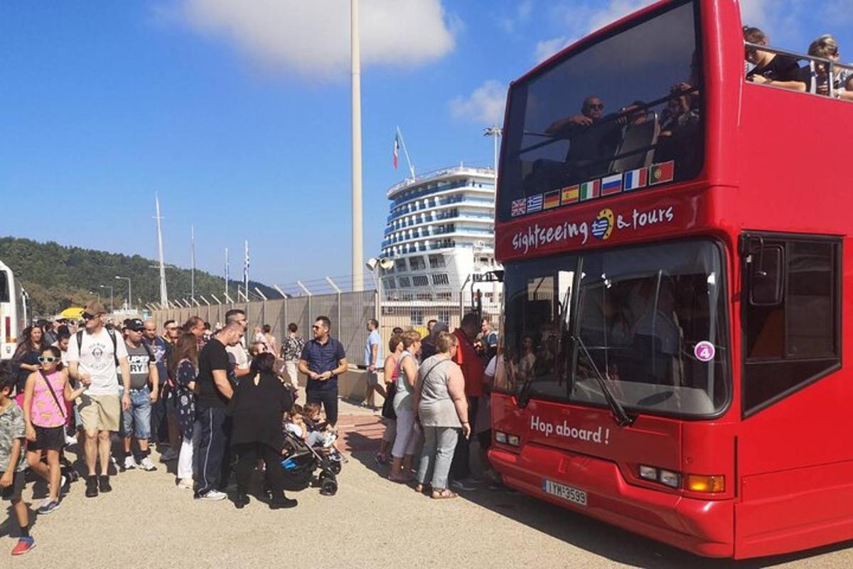 a group of people standing next to a double decker bus