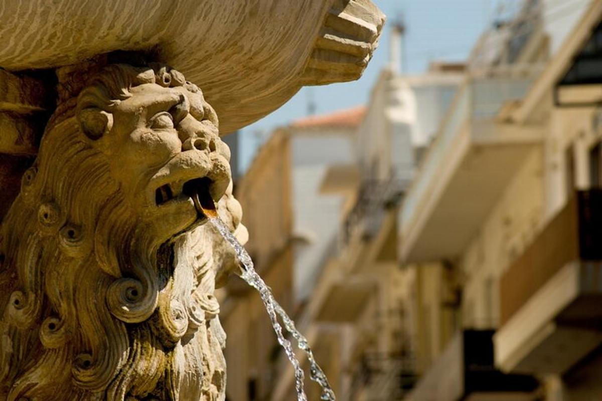 a fountain with a lion head on the side of a building