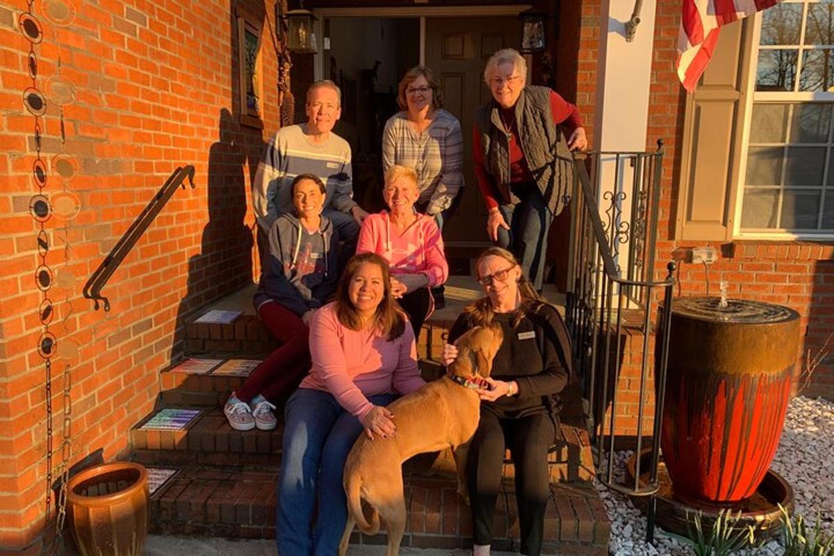a group of people sitting on steps with a dog