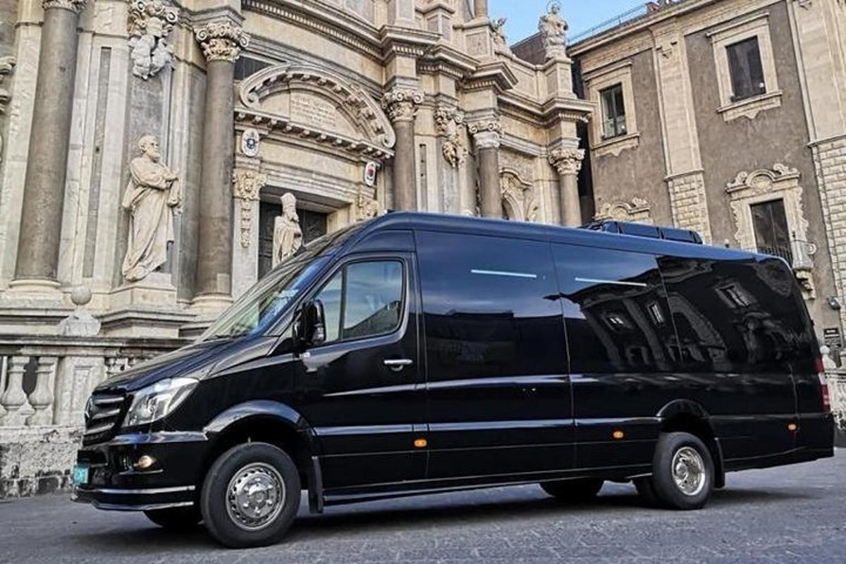 črn kombi parkiran pred stavbo