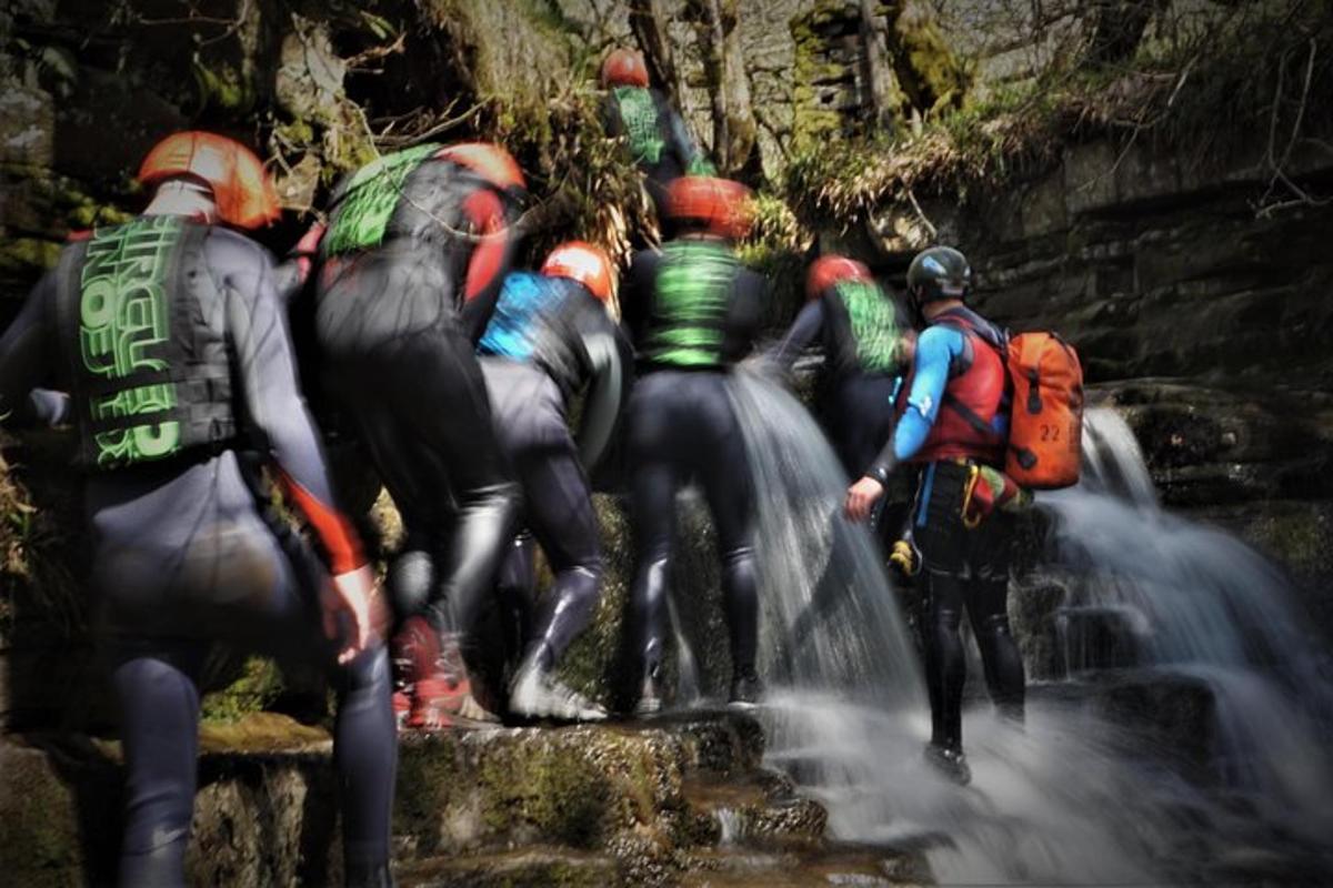 um grupo de pessoas em pé ao lado de uma cachoeira
