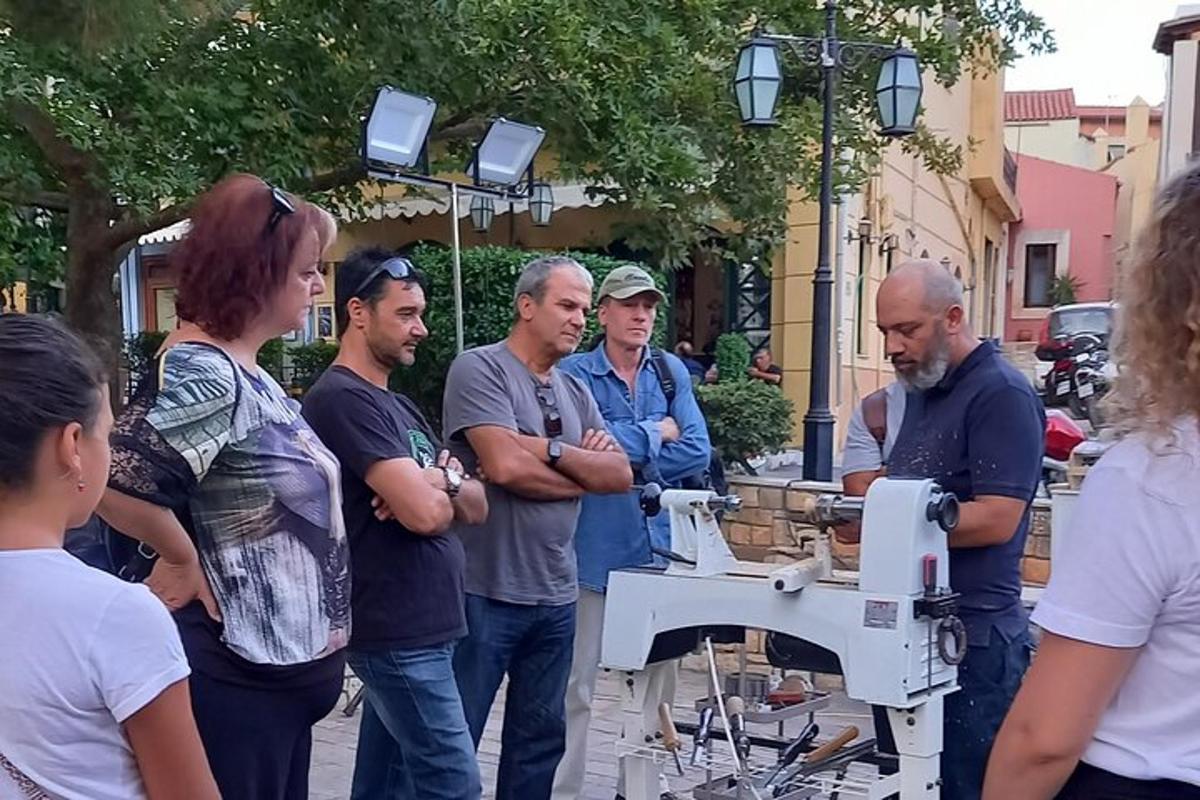 skupina lidí stojících kolem šicího stroje