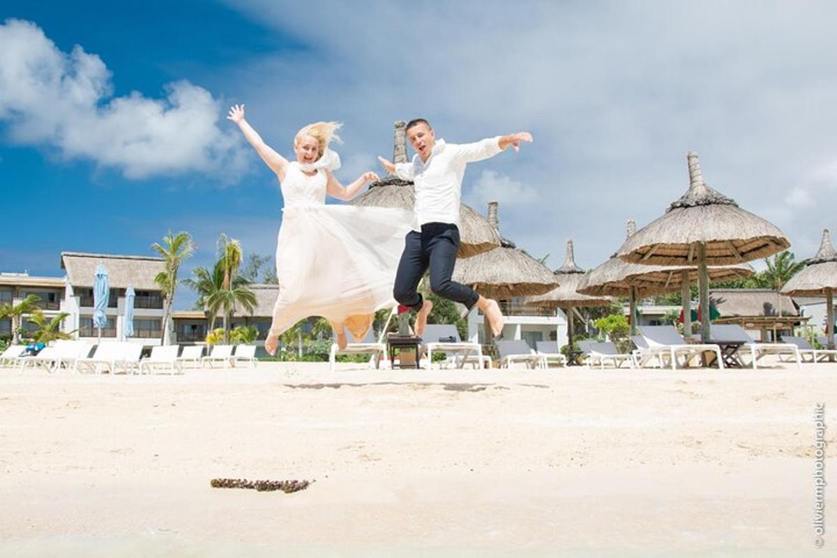 mladenka i mladoženja skaču u zrak na plaži