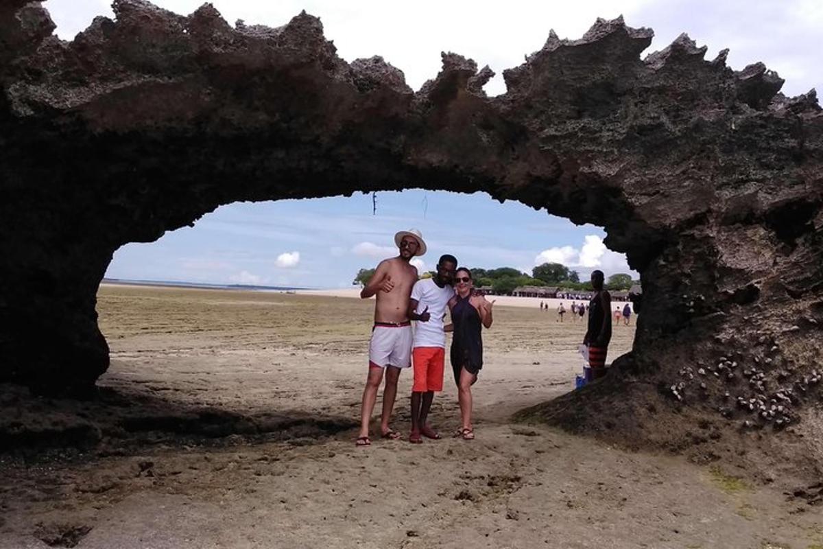 skupina lidí stojících před skalním útvarem