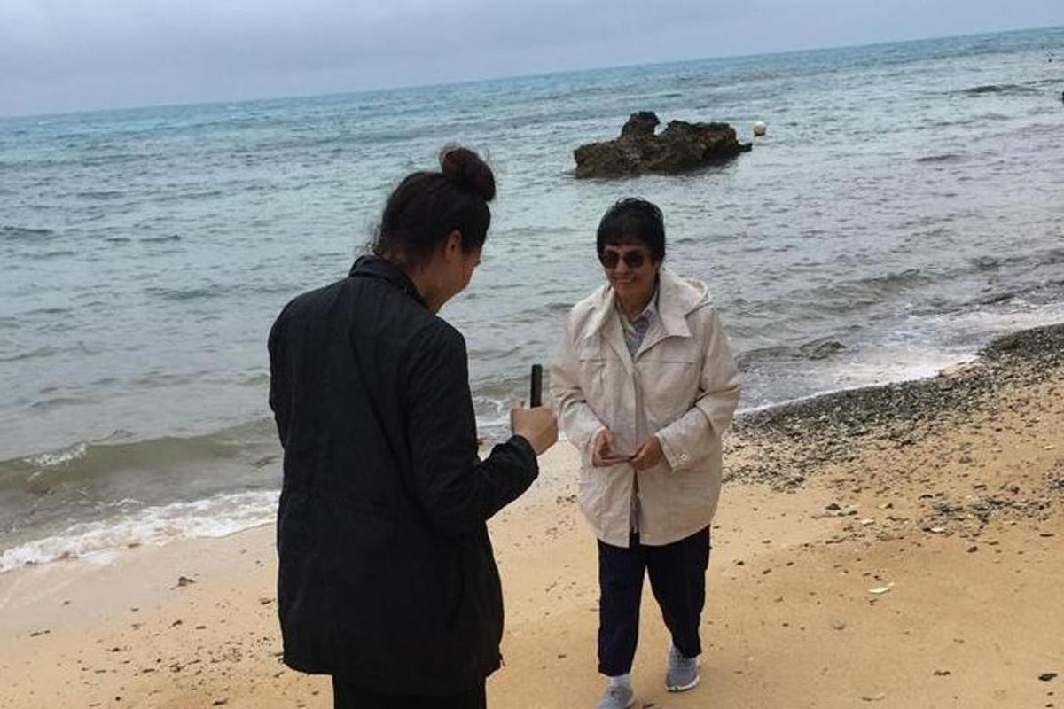 a man taking a picture of a woman on the beach