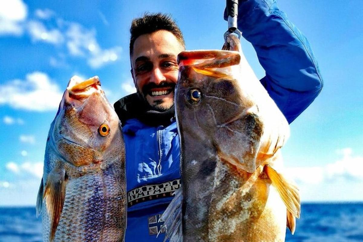 2匹の魚を手に持っている男性