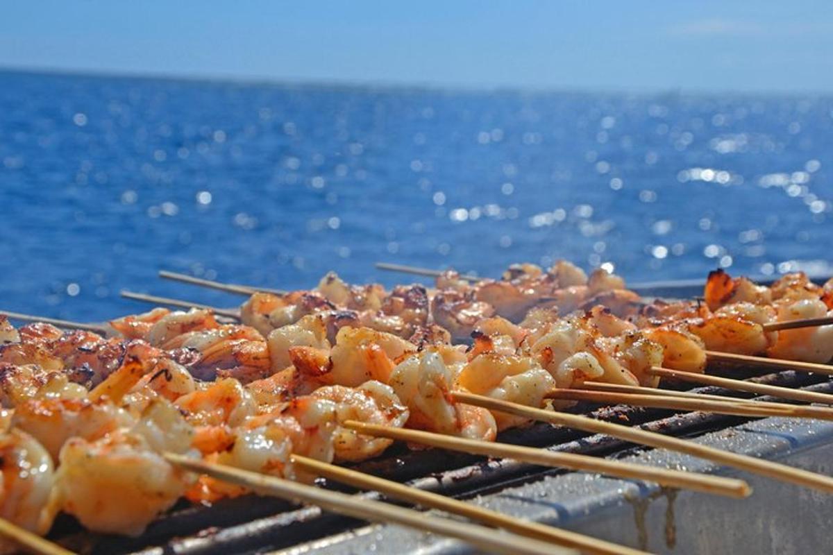 a bunch of food on a grill with chopsticks