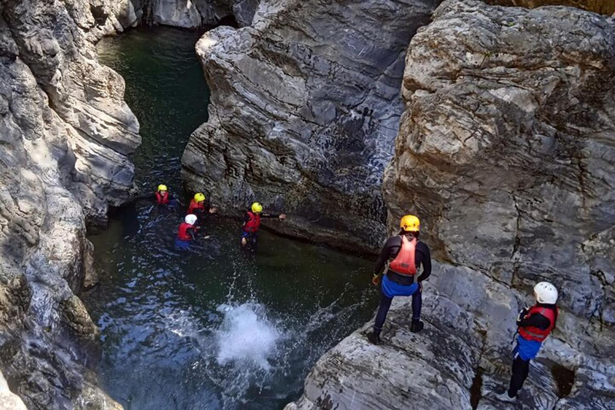 um grupo de pessoas em pé sobre pedras em um rio