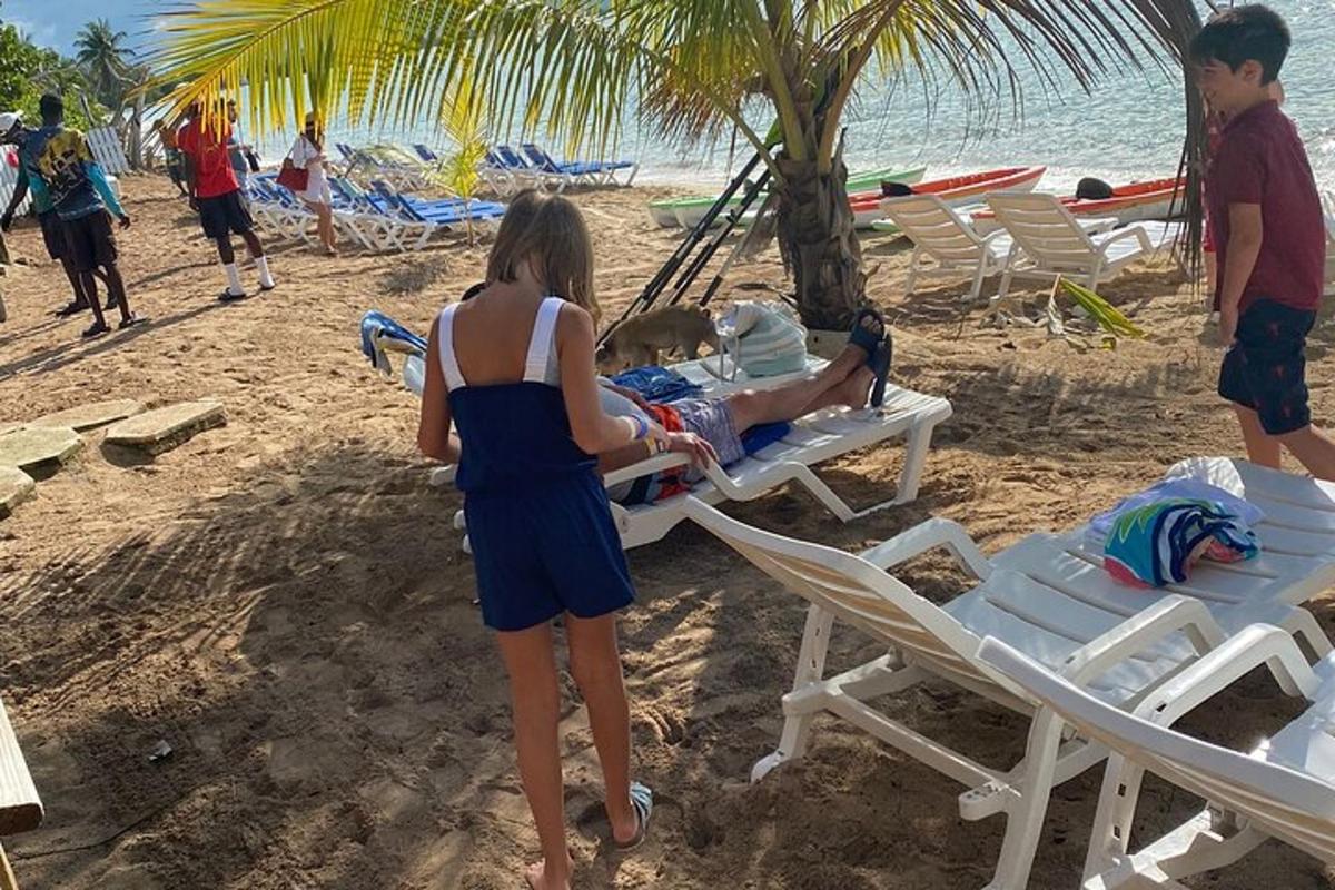 a woman standing on a beach with a child in a hammock