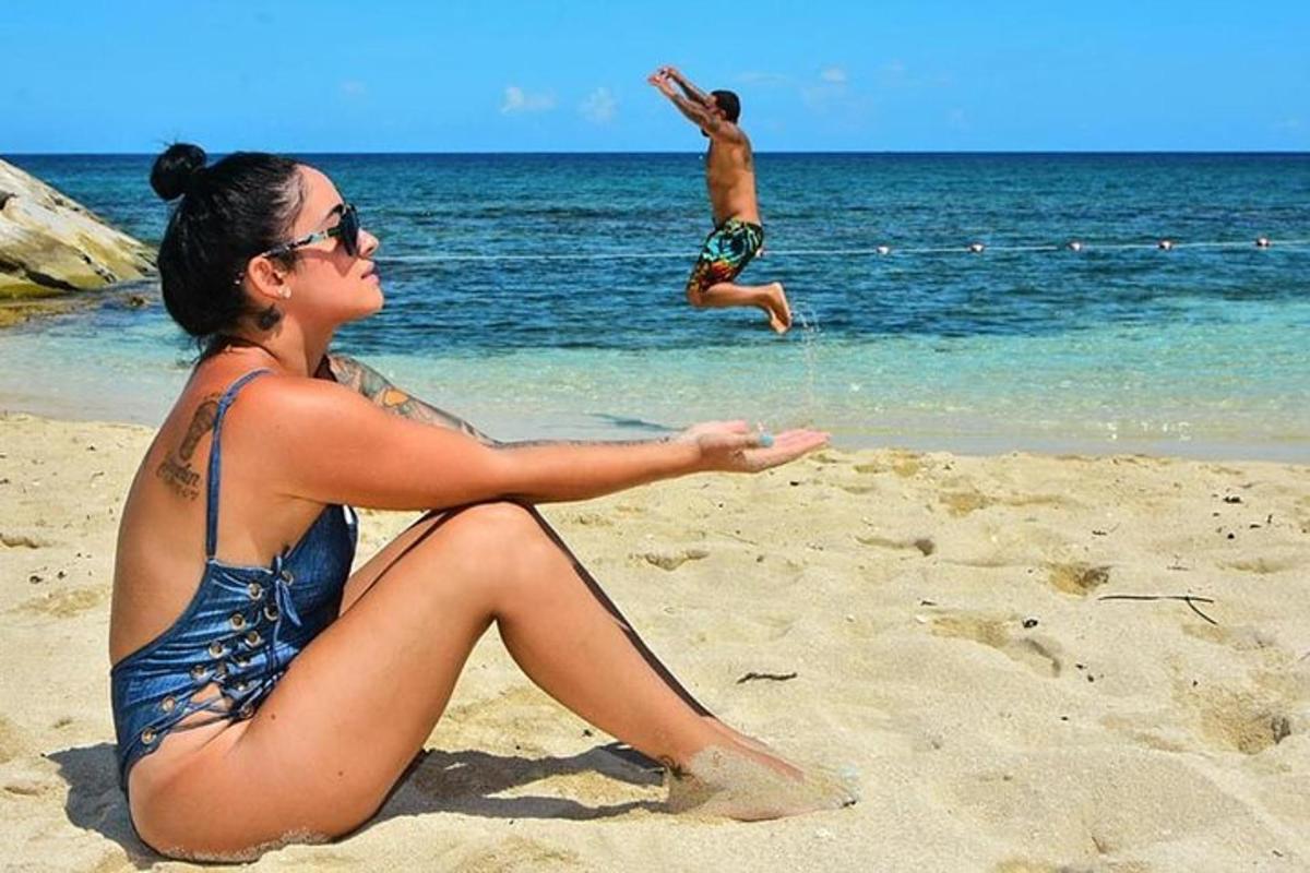 một người phụ nữ ngồi trên bãi biển với một người đàn ông dưới nước