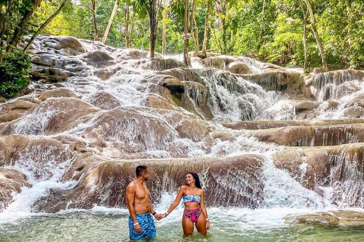 um homem e uma mulher em pé em frente a uma cachoeira