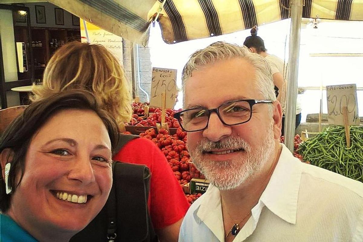 een man en een vrouw poseren voor een foto op een markt