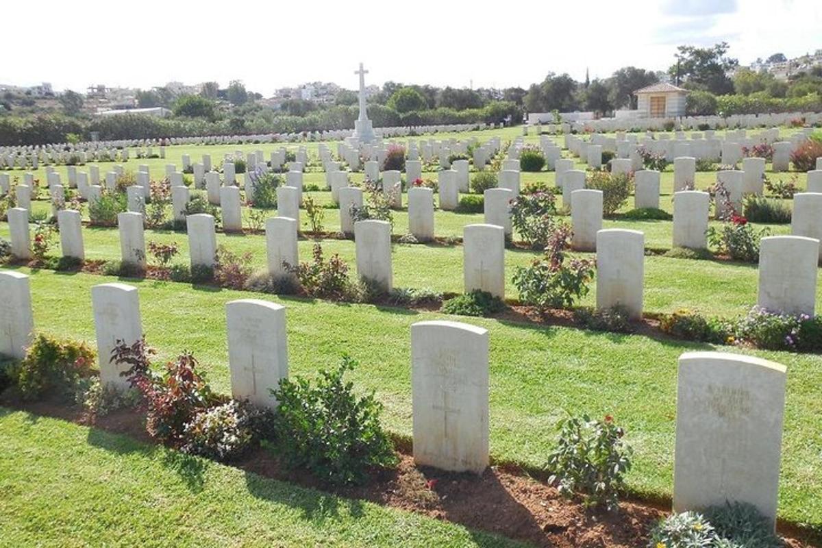 çimlerin arasında beyaz mezar taşlarının bulunduğu bir mezarlık