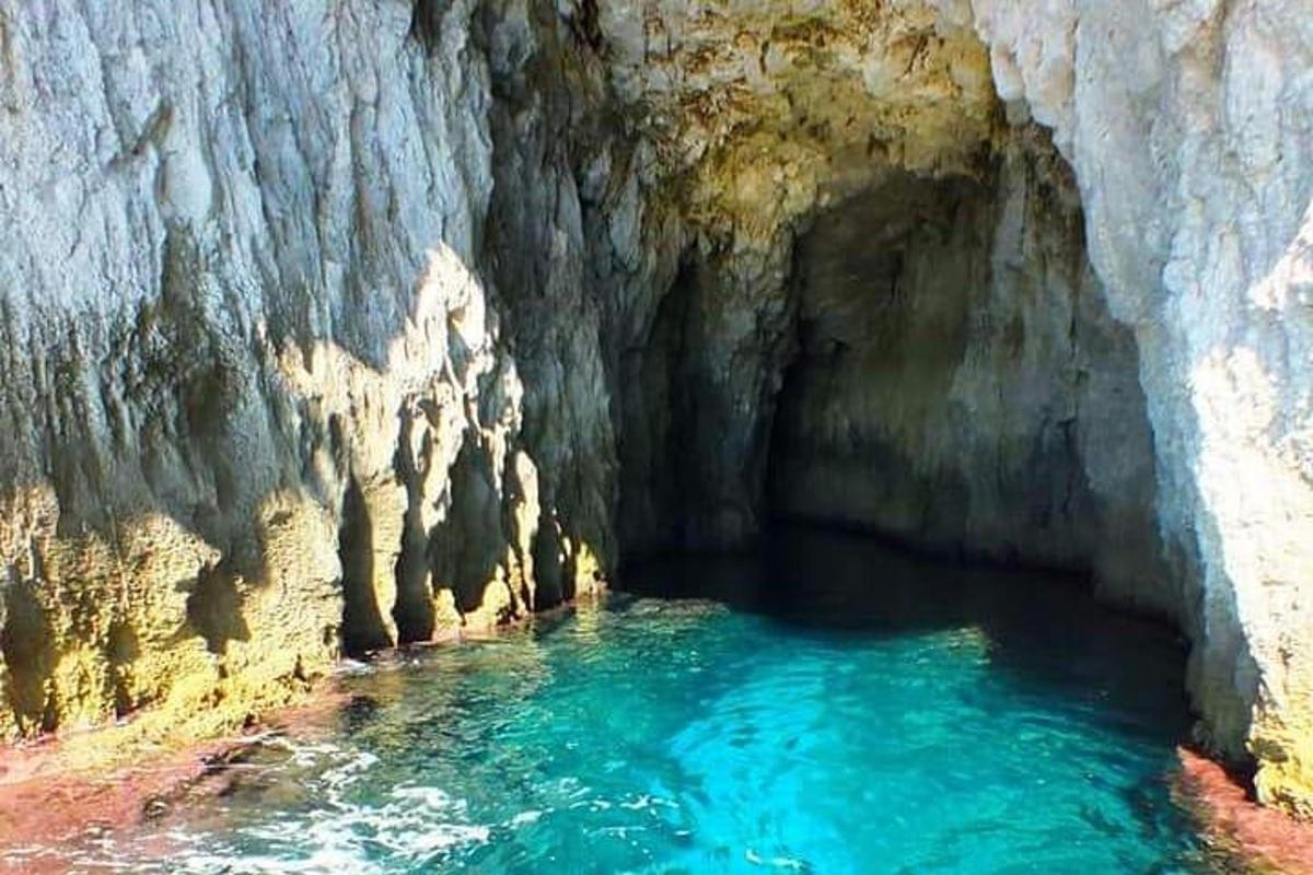 uma piscina azul de água em uma caverna