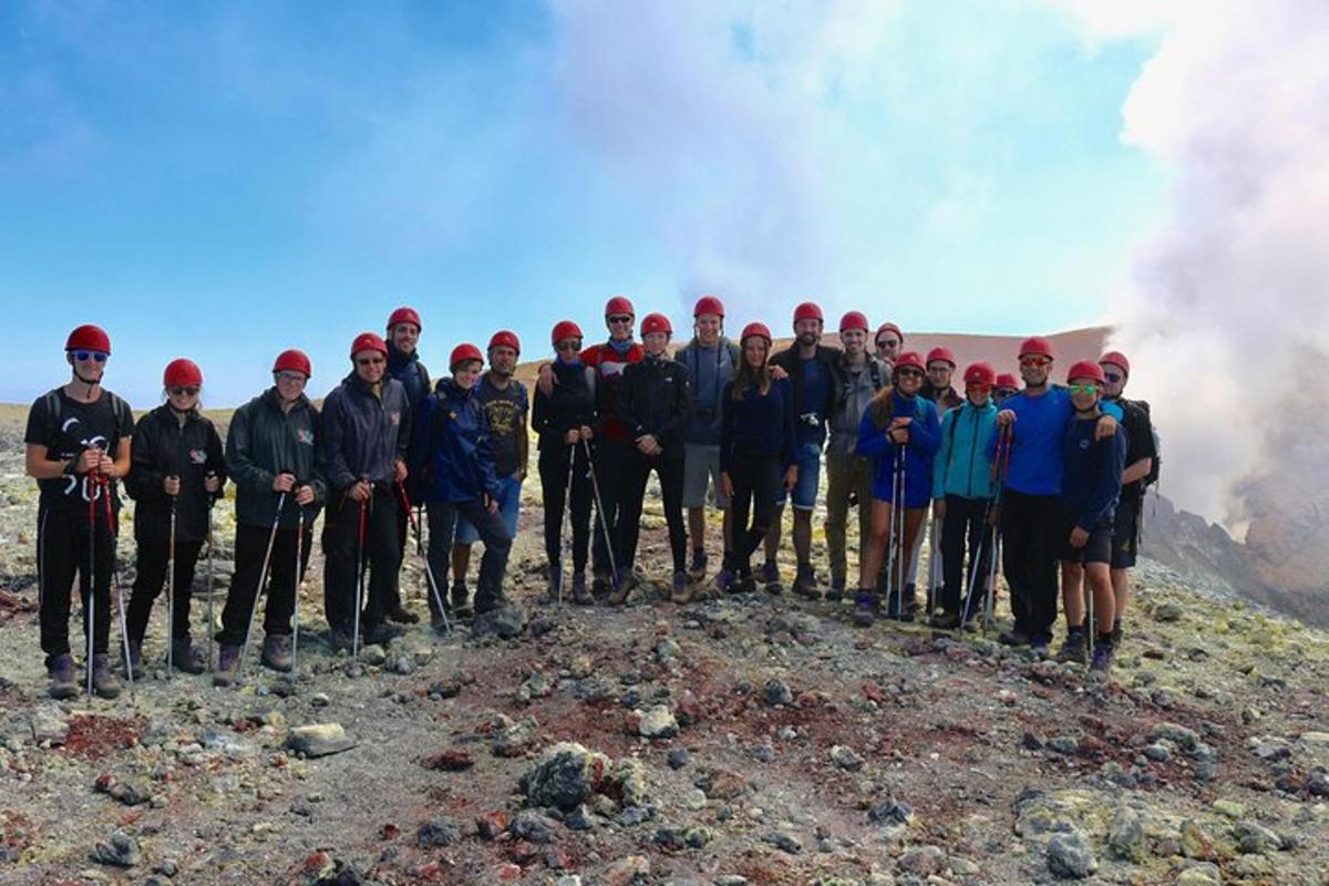 en gruppe mennesker som står på toppen av et fjell
